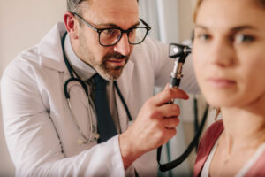 ENT specialist examining a patient with eardrum damage