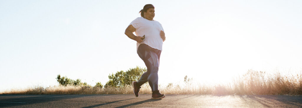 Overweight person walking with a glucose monitor in hand, symbolizing weight loss with type 2 diabetes