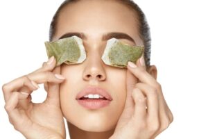 Woman applying cold compress under eyes