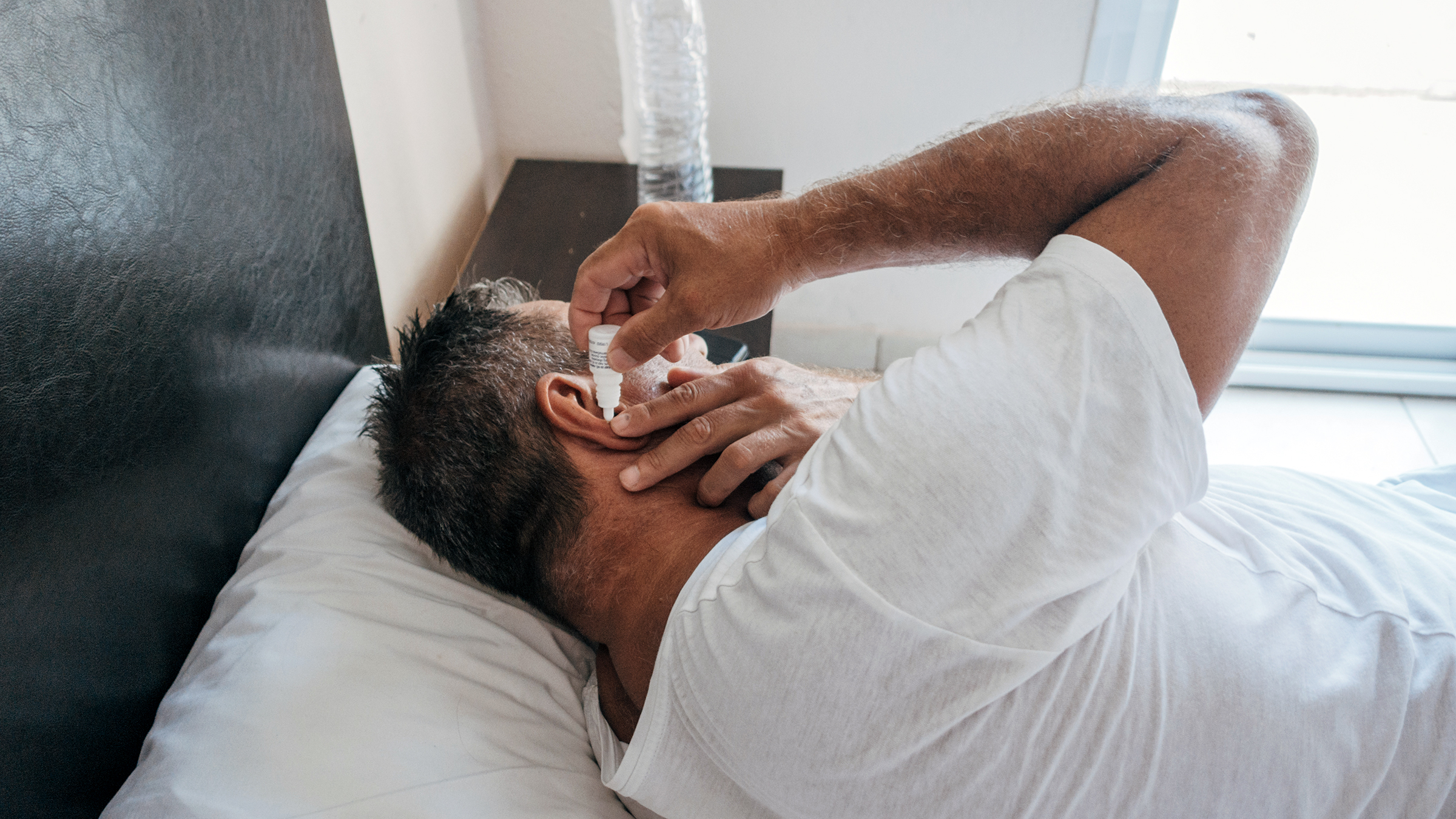 Applying warm compress to relieve clogged ear pressure naturally