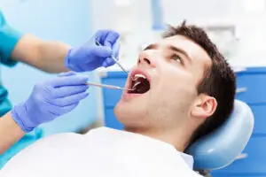 • Dentist examining a patient’s teeth for signs of oral disease